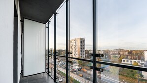 A balcony with a view of a cityscape, including a tall building and a busy road with vehicles. - Varsovia Comfort 629 (Warszawa)