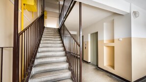 A staircase with a metal railing leading to a landing. - Rakowiec Blue Studio (Warszawa)