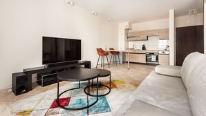 Een moderne woonkamer met een flatscreen televisie, een bank en een salontafel.