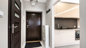 Una cocina moderna con armarios blancos, encimera negra y horno integrado.