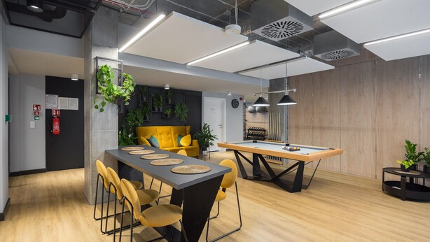 A modern meeting room with a long table, yellow chairs, and a pool table. - Business Park Blue Studio (Warszawa)