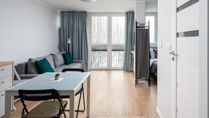 Una habitación moderna y bien iluminada con una mesa de comedor, un sofá y una cama.