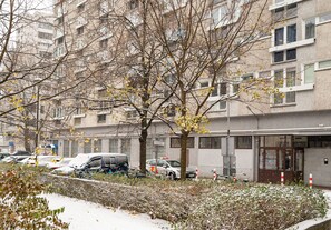 A multi-story residential building with a parking area in front.