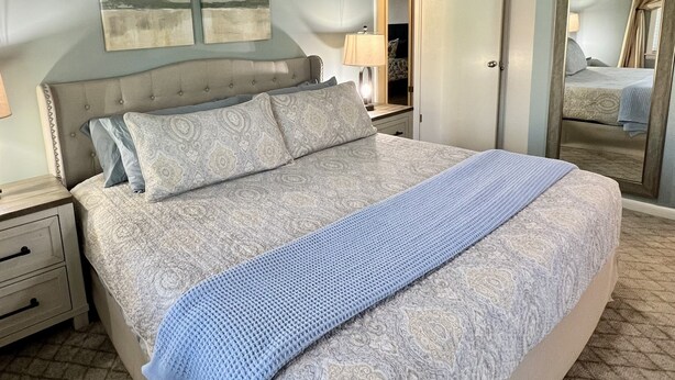 A bedroom with a bed, a ceiling fan, a nightstand, a dresser, and a mirror. - Home in Disney - Ride Directly to Trails, 1/2 mile to Marina & Boat Ramp (Disney)