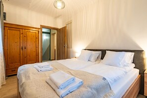 A hotel room with a large bed, wooden wardrobe, and a mirror. - Willa Cosy Bielsko-Biała (Bielsko-Biała)