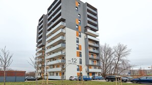 A multi-story residential building with balconies, labeled "UNII 12 LUBELSKIEJ." - 10th Floor Unii Lubelskiej Apartment (Poznań)