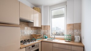 Una cocina moderna con estufa a gas, horno y ventana con vista a la ciudad.