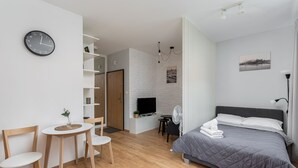 A modern bedroom with a bed, a TV, a desk, and a chair. - Cracow Novum Apartment #58 (Kraków)