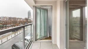 En balkon med en glasdør, der giver udsigt over byen.