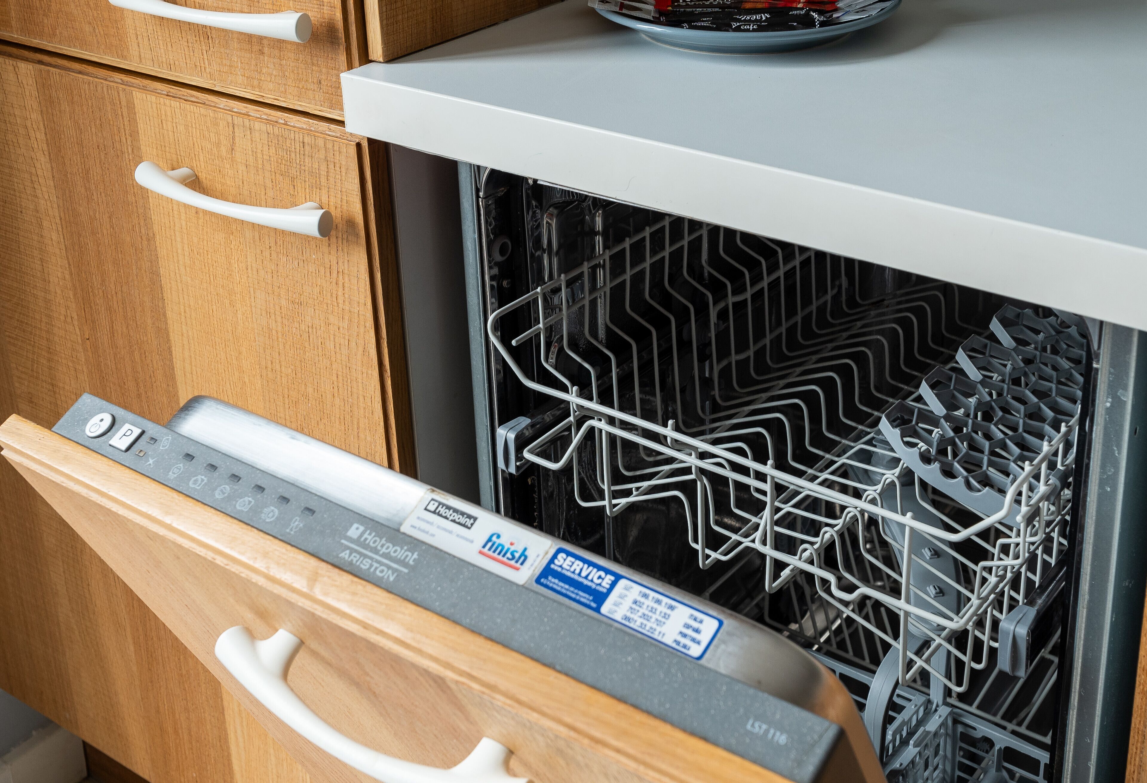 A dishwasher with a control panel and a rack inside.