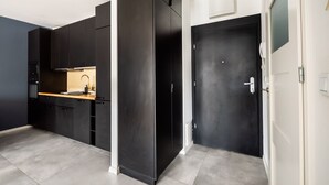Una cocina moderna con armarios oscuros, encimera de madera y horno empotrado.