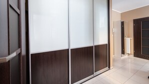 A modern room with a sliding glass door, a wooden floor, and a white tiled floor. - Park Praski 2-Bedroom Apartment (Warszawa)