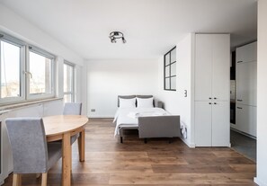 A modern bedroom with a bed, bedside tables, and a window.