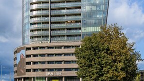 A modern high-rise building with a glass facade and a sign reading "HANZA TOWER".