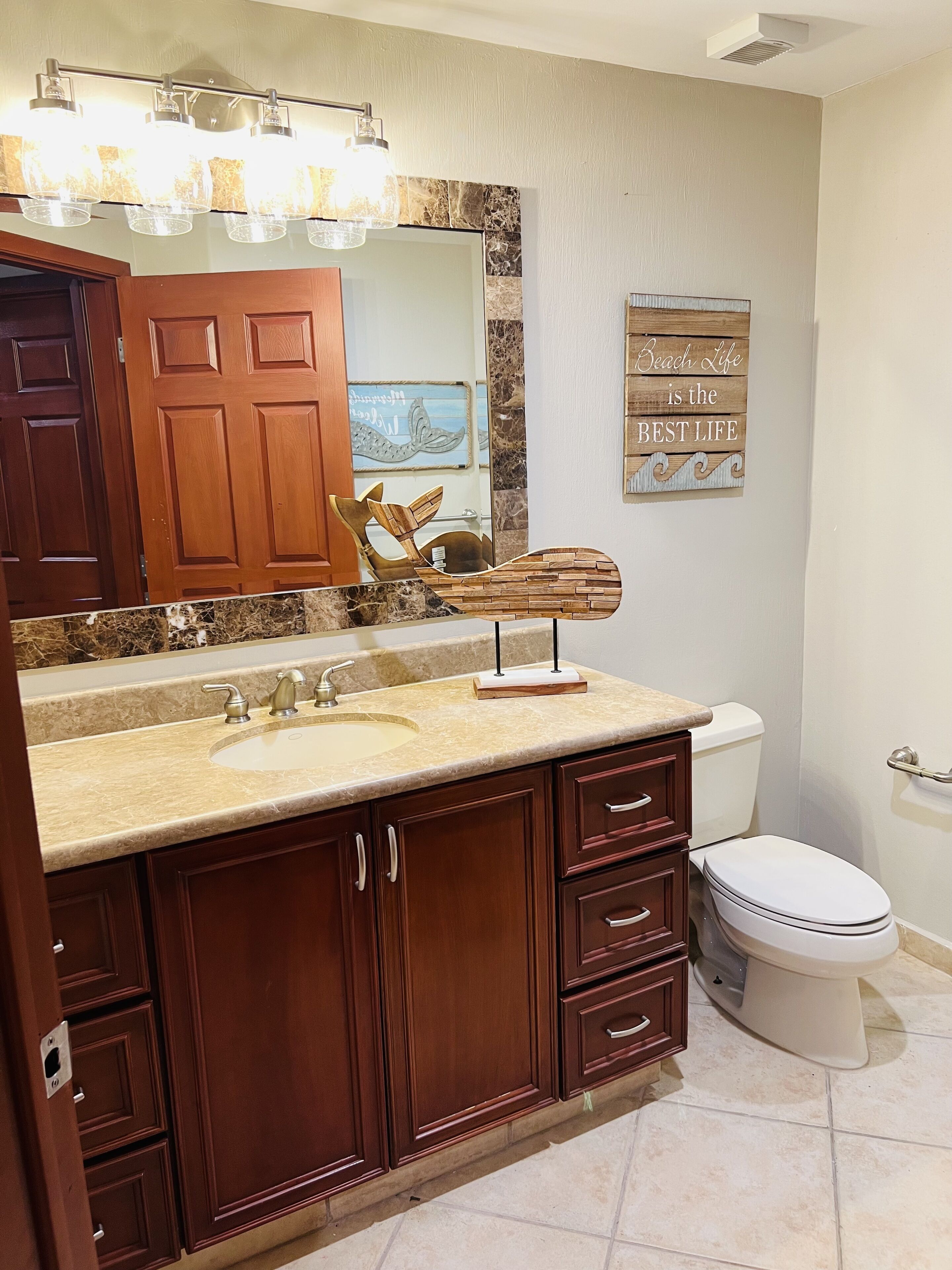 Une salle de bain avec un meuble-lavabo, un lavabo et des toilettes.