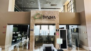 A lobby with a 'Citron Fine Cuisine' sign, a seating area, and a glass storefront. - Beautiful 3 bedroom/3 bathroom Condo In Las Palomas Beach & Golf Resort (Puerto Penasco)