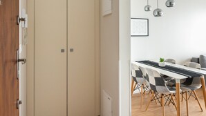 Une cuisine moderne avec des meubles en bois, un plan de travail blanc et un luminaire suspendu.