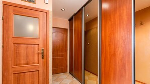 Un passadís amb portes de fusta i una porta corredissa de vidre.