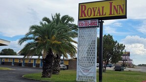 A Royal Inn sign with a contact number and a notice about new management. - Royal Inn (Kenedy)