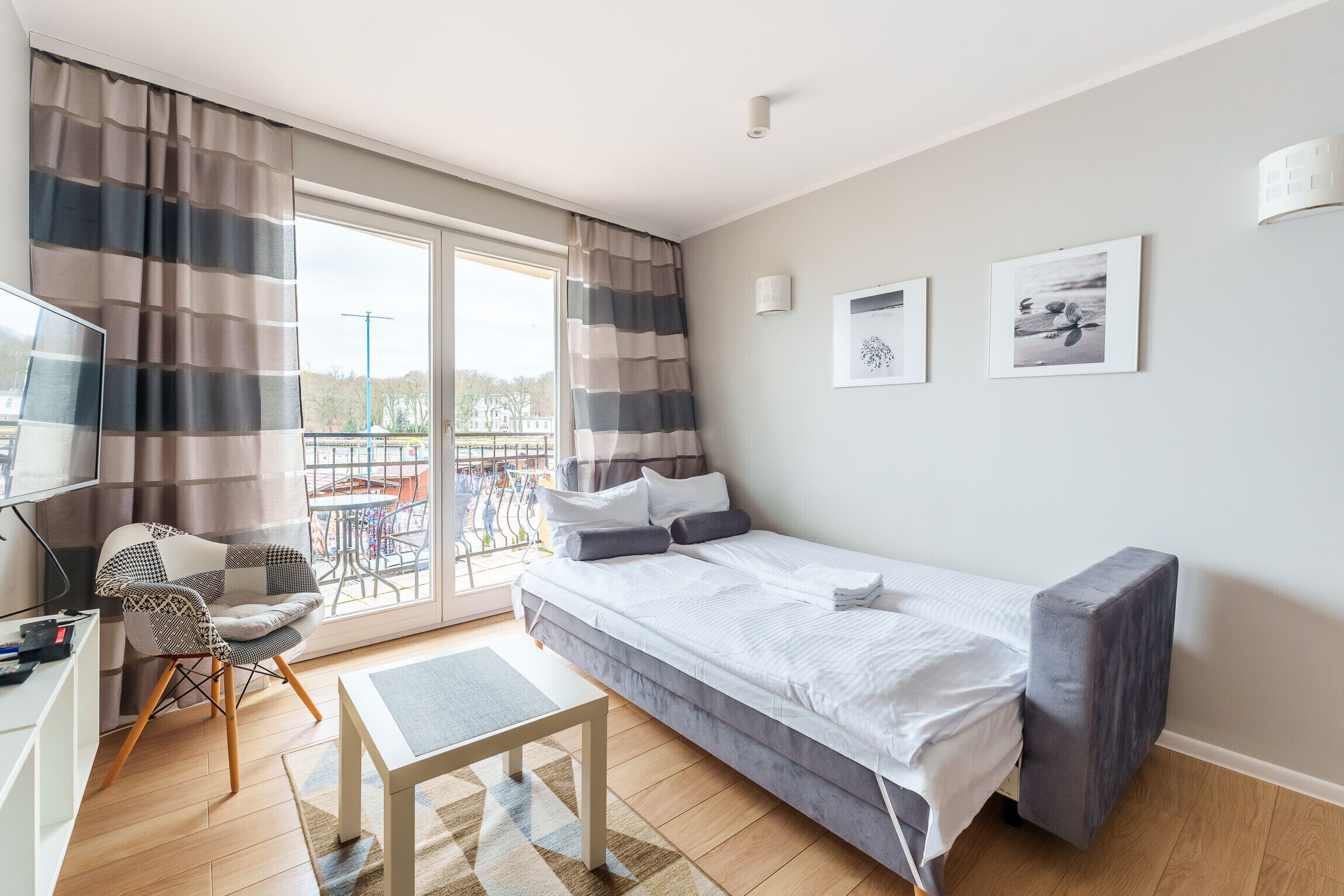 Una habitación de hotel moderna con cama, escritorio, silla y balcón con vistas.