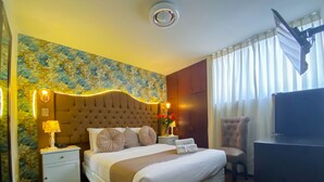 A hotel room with a large bed, a TV, a desk, and a chair. - Hotels Collect A. Monet (Arequipa)