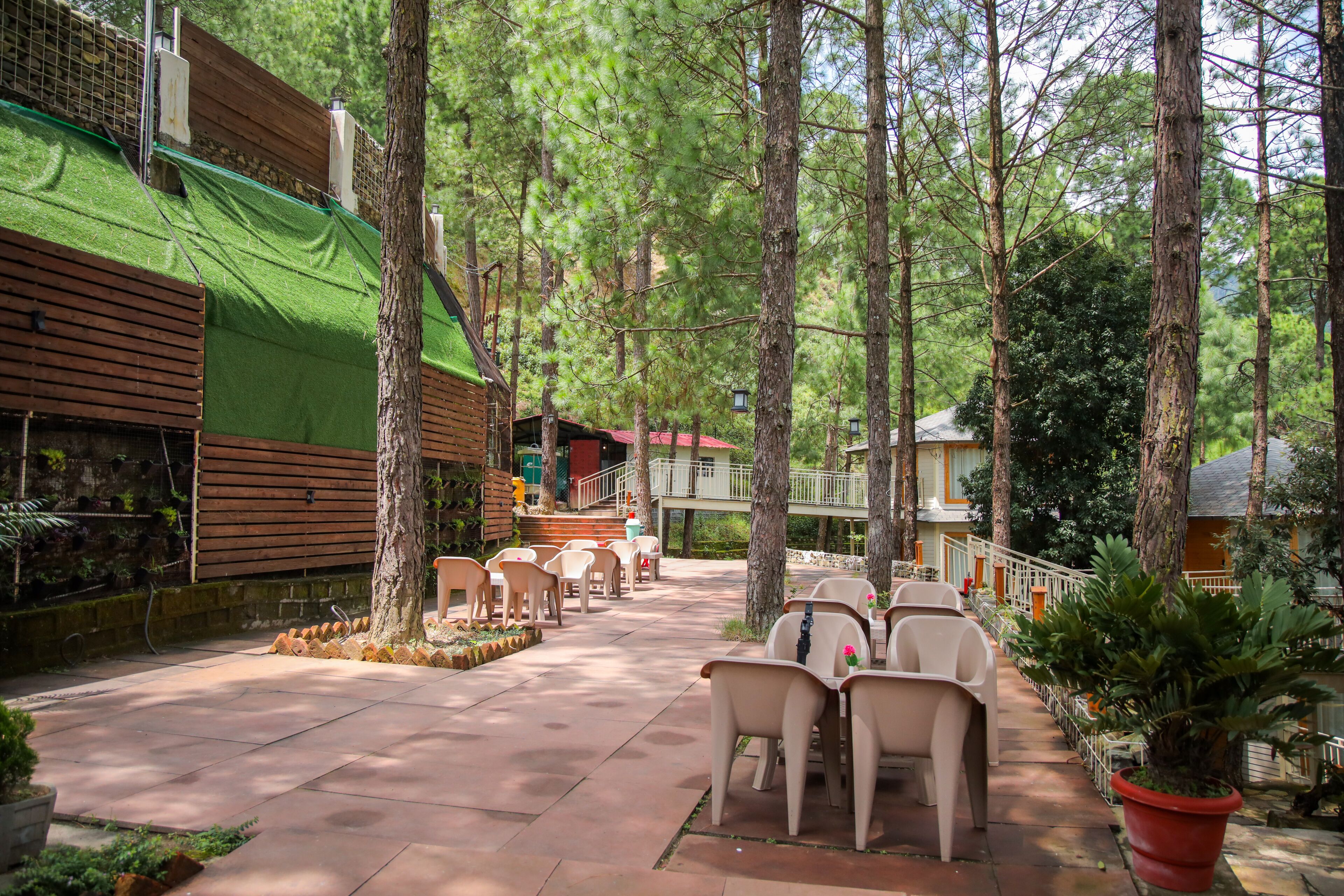 A covered outdoor area with seating and a staircase leading to a building.