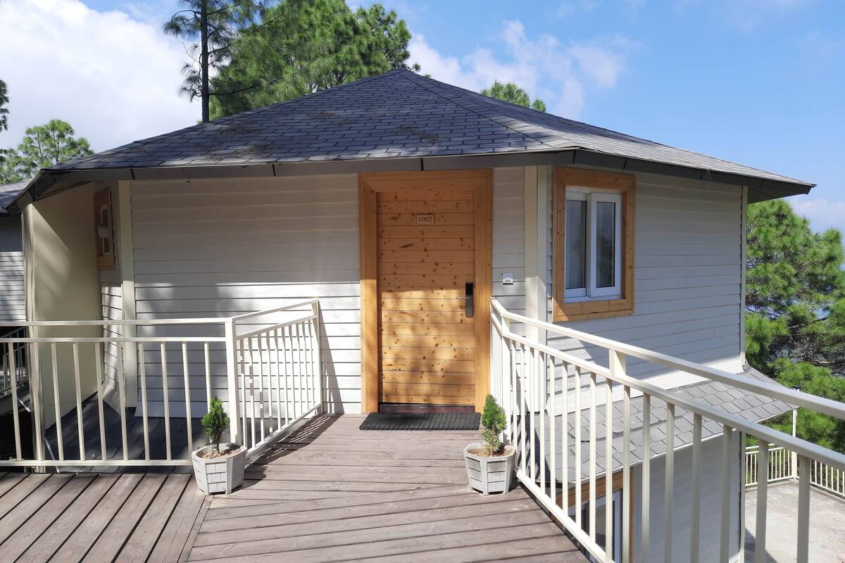 Ein Holzhaus mit Veranda, Tür und Fenster.