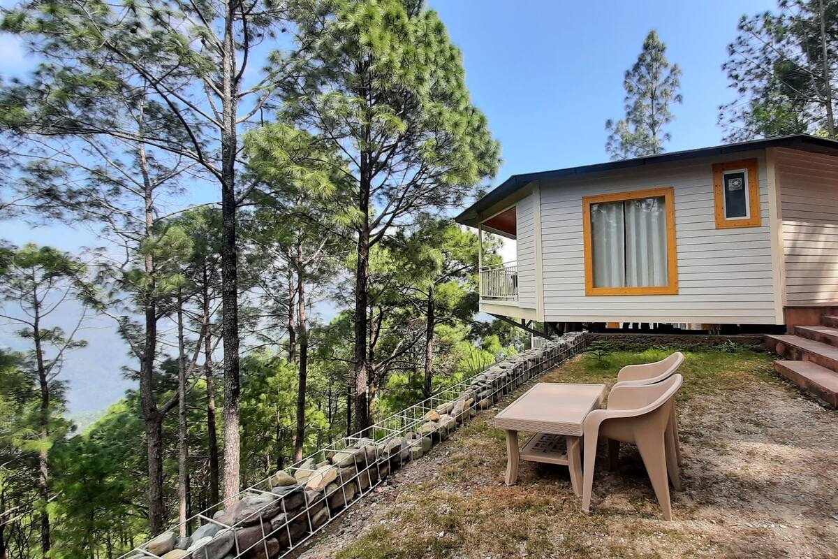 Eine Hütte mit Balkon, einer kleinen Veranda und einer Steinstützmauer.