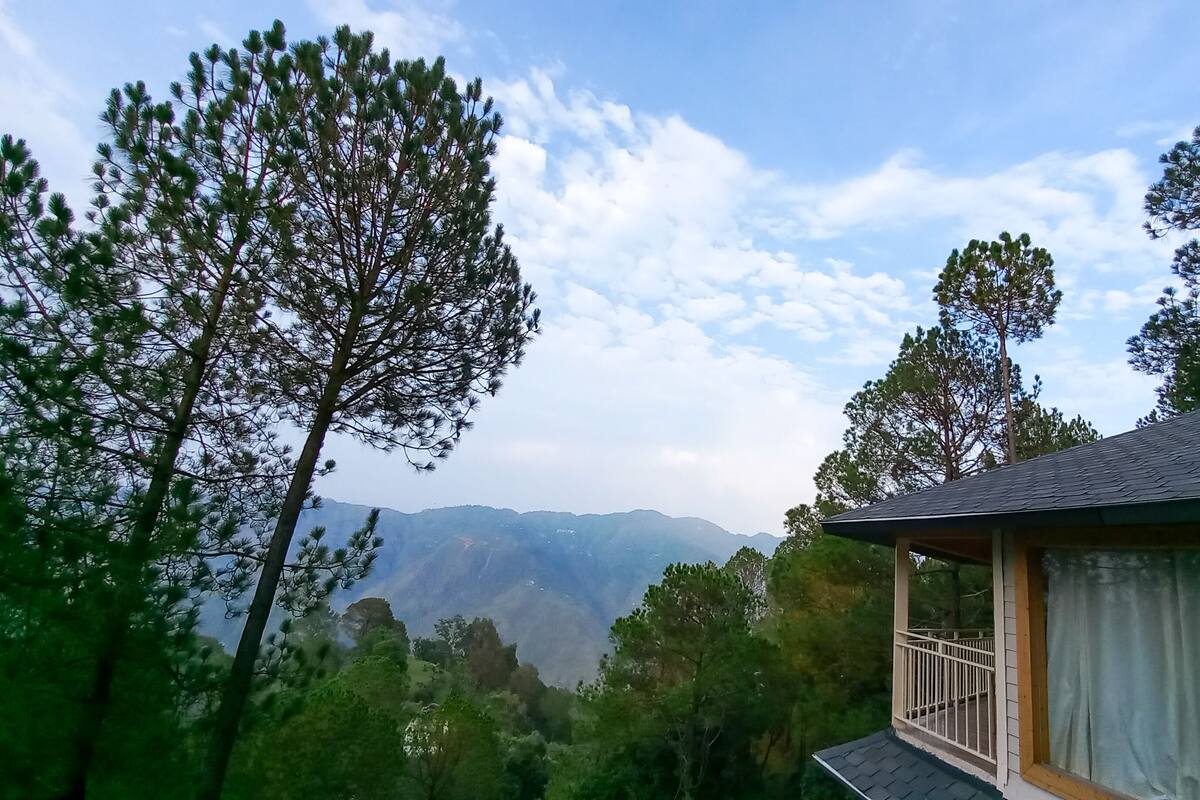 Eine Hütte mit Balkon und Blick auf eine gebirgige Landschaft.