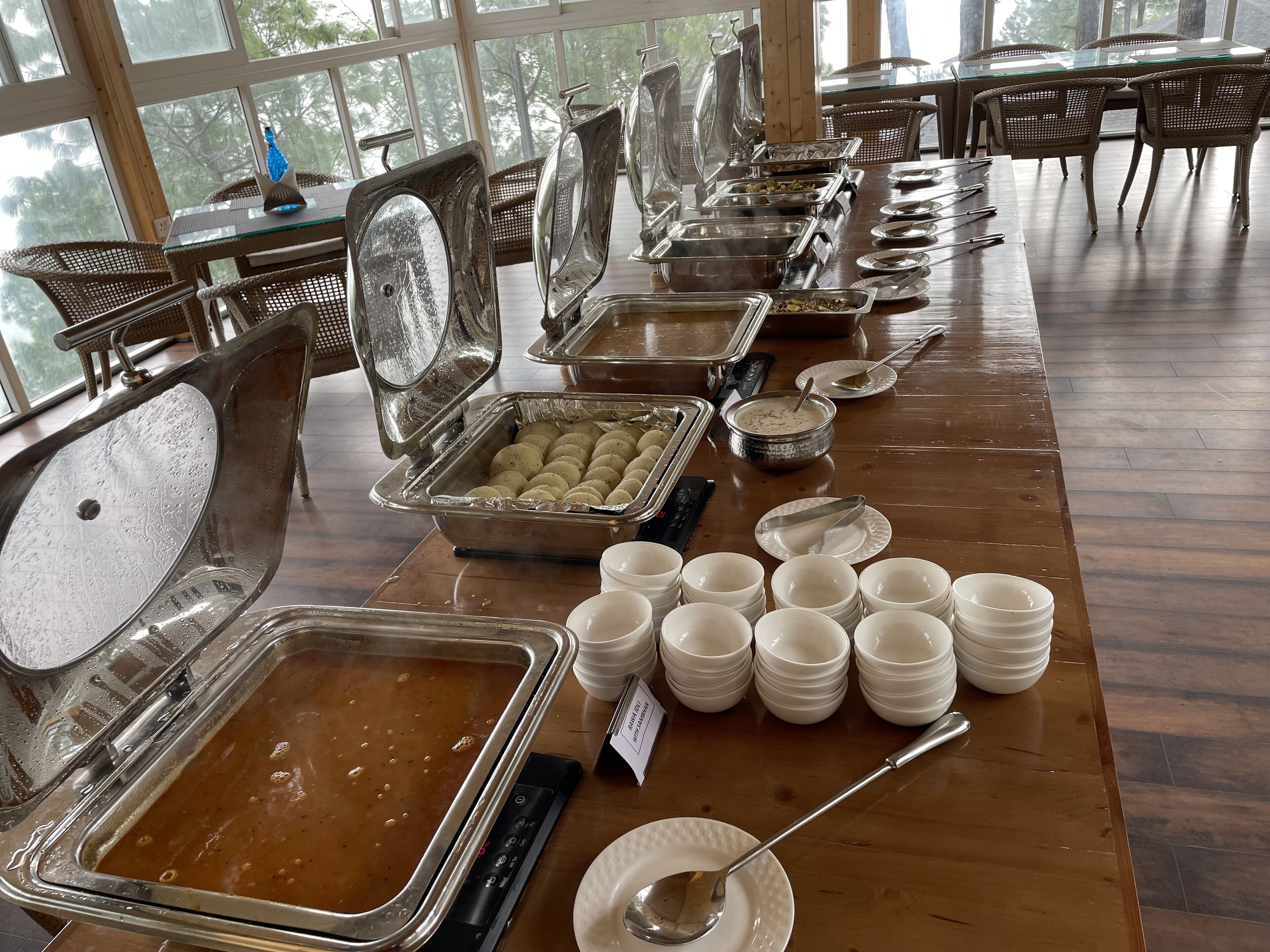 Un buffet avec différents récipients contenant de la nourriture et des ustensiles de service.