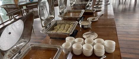 Un buffet avec différents récipients contenant de la nourriture et des ustensiles de service.