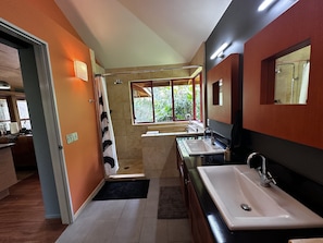 A modern bathroom with a shower, two sinks, and a large window providing natural light. - Tree Top Suite- Beautiful walk to Hanalei Bay (Princeville)