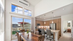 Una cocina moderna con una isla central, armarios de madera y electrodomésticos de acero inoxidable.