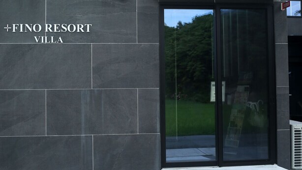 A modern building entrance with a sign reading "+FINO RESORT VILLA". - PLUFINO RESORT VILLA (Ise)