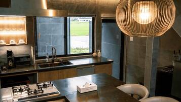 A modern kitchen with a gas stove, sink, and a large window.