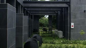 A modern building with a covered outdoor area featuring a table and chairs. - PLUFINO RESORT VILLA (Ise)
