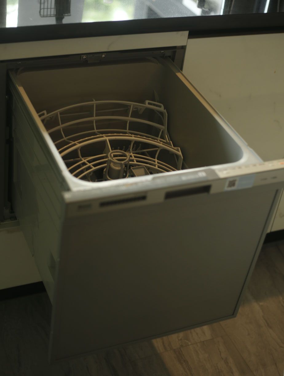 An open dishwasher with a visible rack and control panel.