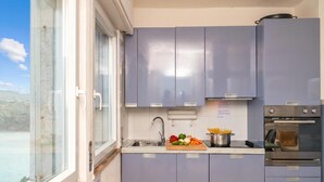 Une cuisine avec une fenêtre, un évier, des placards et un four.