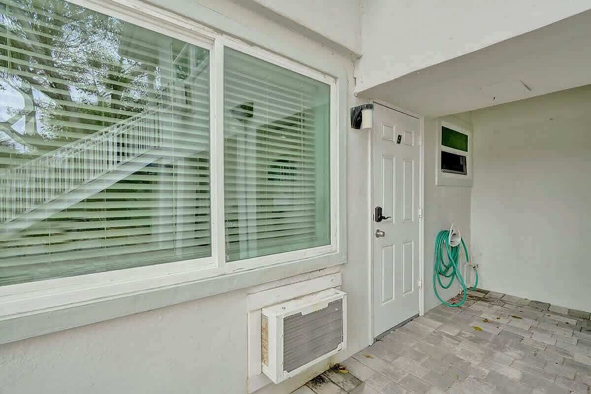 A room with a large window, a door, and a small window.