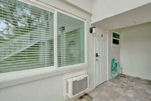 Une pièce avec une grande fenêtre, une porte et une petite fenêtre.