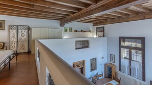 Una habitación con techo de madera, una cama, una mesa de comedor y un ventanal.