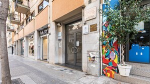 Une vue de rue avec un bâtiment abritant un magasin de « talc », une fresque murale colorée et un arbre.