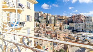 A cityscape with a building featuring balconies and a staircase.