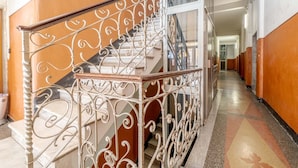 A staircase with ornate metal railings and a handrail, leading to an upper floor.