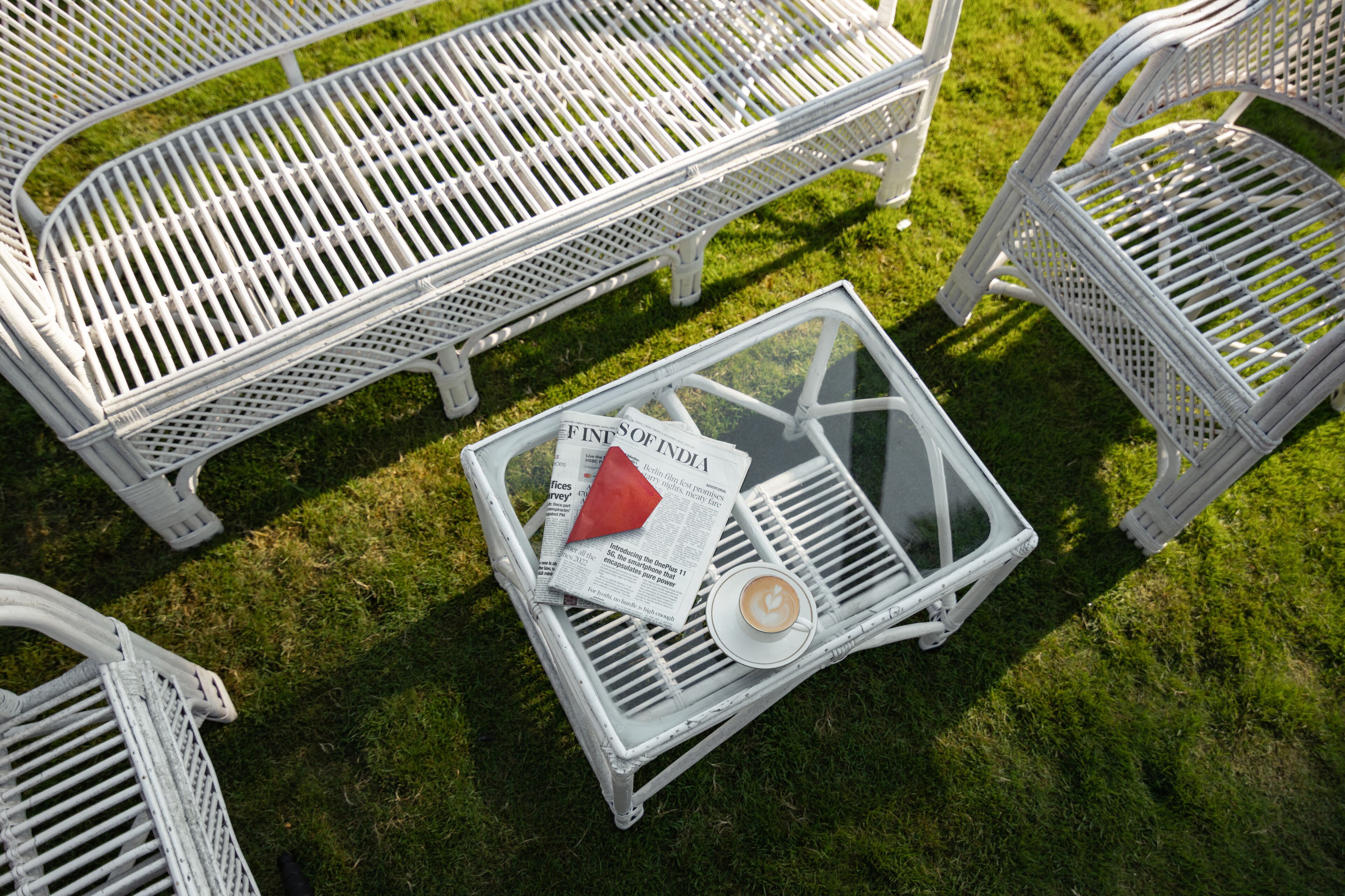 Ein weißer Sitzbereich im Freien mit Stühlen und einem Tisch.