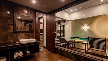 Bathroom features a large mirror, sink, and dark tile flooring.