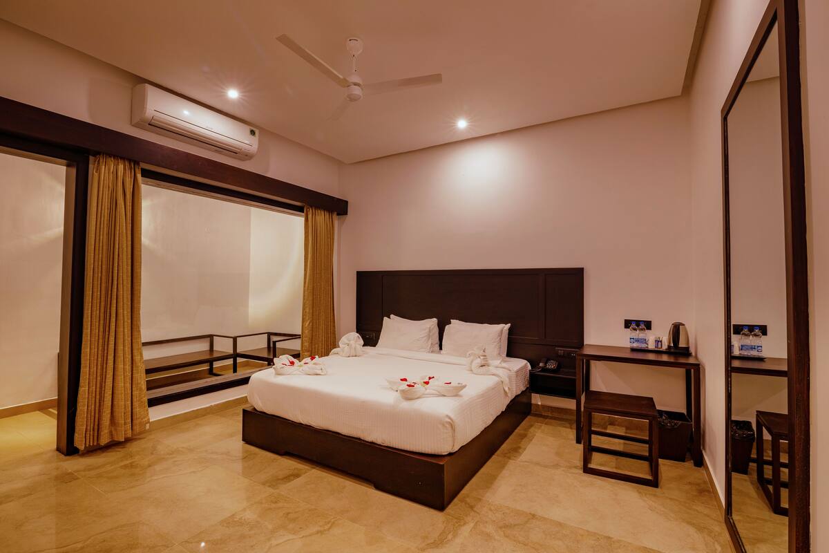 Una habitación de hotel moderna con una cama grande, un escritorio y un espejo.