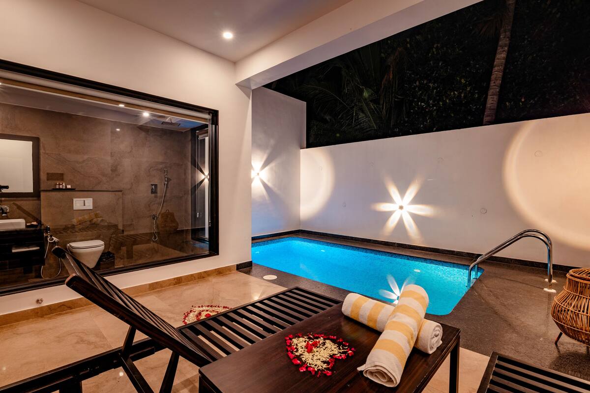 Un baño moderno con ducha de vidrio, bañera y una pequeña zona de piscina.