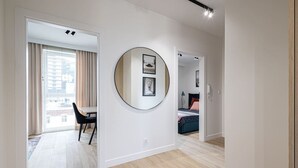 A modern room with a dining area, a large mirror, and a bed. - Cuero | Centrum | Garaż podziemny | Dwie sypialnie (Bydgoszcz)
