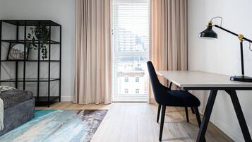 Habitació moderna amb escriptori, cadira i prestatgeria.
